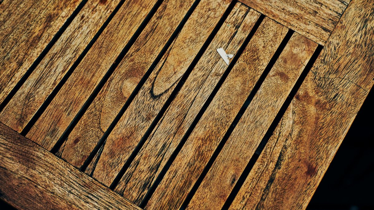 Close-up of a rustic wooden table showcasing unique grain patterns from above.