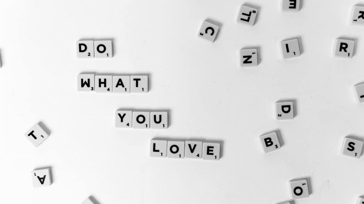 Scrabble tiles spell 'Do What You Love' on a white background.