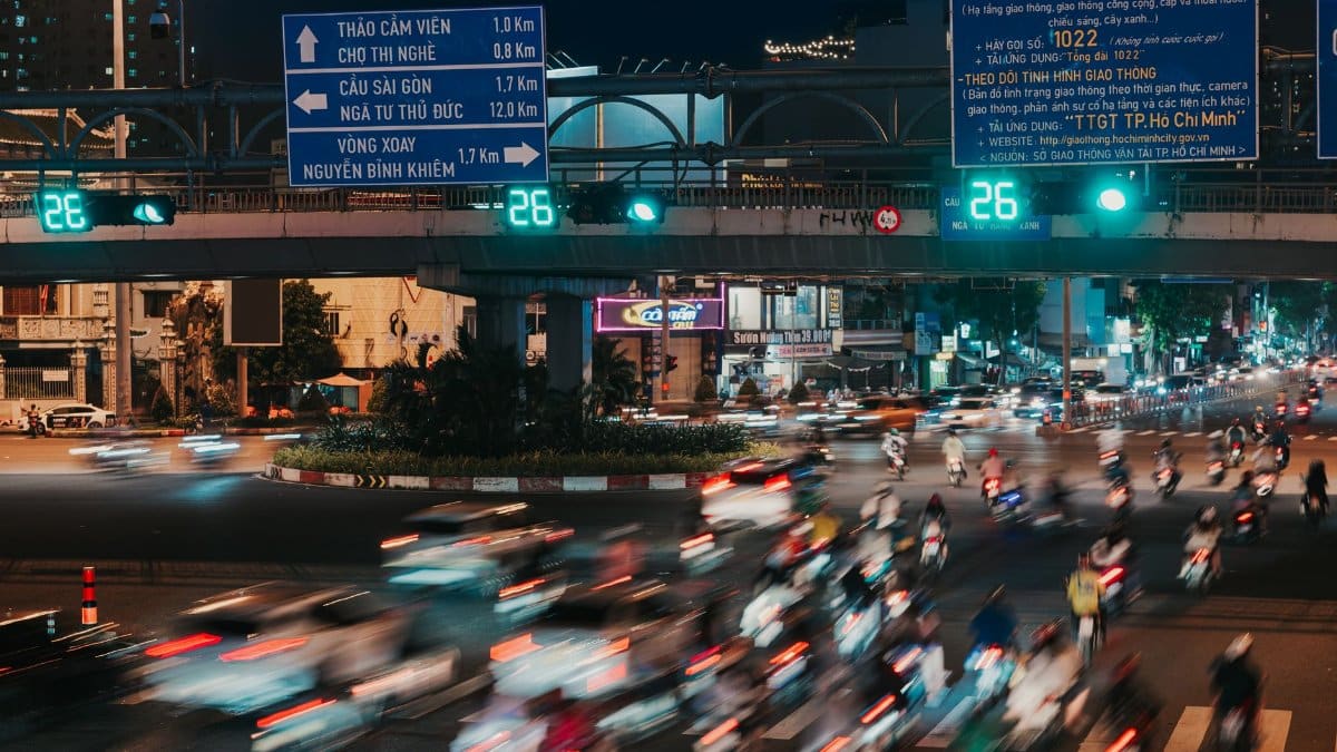 Dynamic night traffic with blurred motion in Ho Chi Minh City, highlighting urban life and energy.
