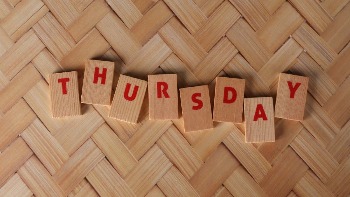 Thursday spelled out with wooden blocks on a woven pattern surface, offering a natural texture.