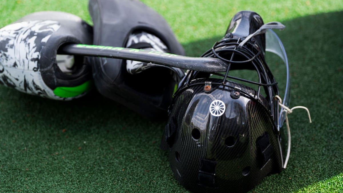 Catcher's helmet and pads on artificial turf, standard baseball equipment.