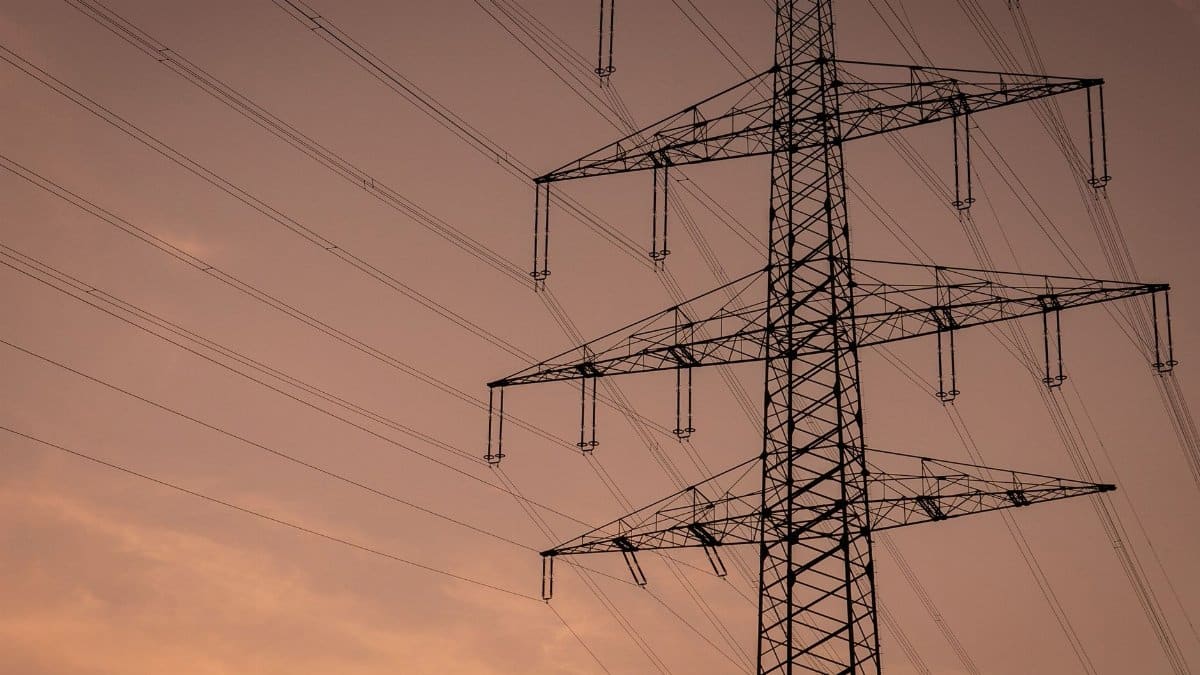 Silhouette of a transmission tower against a pink sunset sky in Germany.