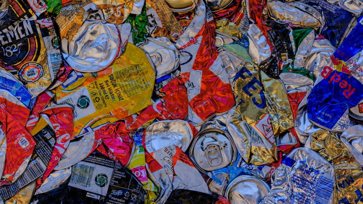 A vibrant display of crushed aluminum cans showcasing recycling art with a colorful pattern.