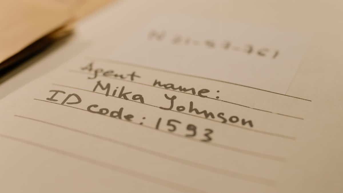 Handwritten document with agent name and ID code, showcasing personal handwritten text.