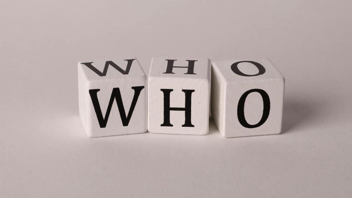 Three wooden alphabet blocks spelling 'WHO' on a white background, perfect for word games or educational content.