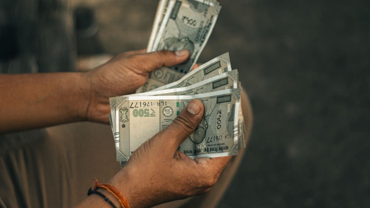 Close-up of hands holding multiple 500 Indian Rupee notes, representing wealth and financial transactions.