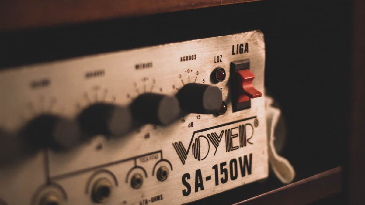 Closeup of old electronic audio equipment amplifier with metal control panel placed in cabinet