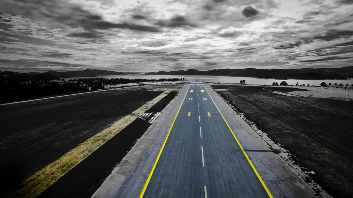 Aerial shot of a runway at Kjevik Airport, Norway under a dramatic sky