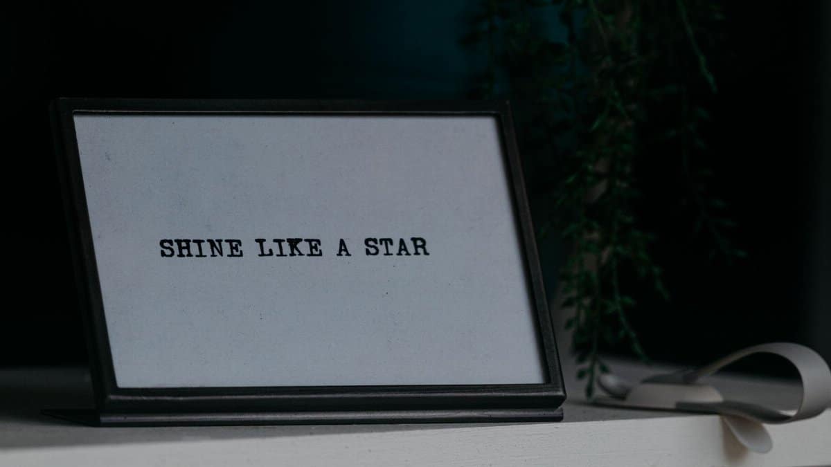 Motivational quote 'Shine Like a Star' in a black frame on a desk.