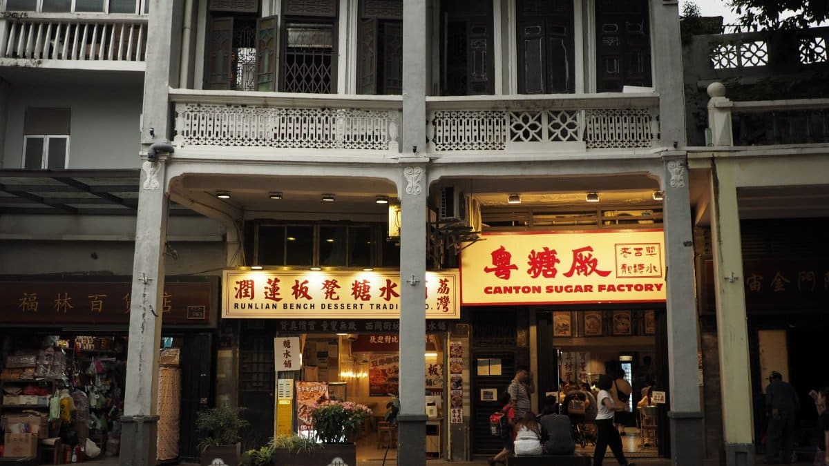 Charming street view of Canton Sugar Factory in traditional architecture, bustling with people.