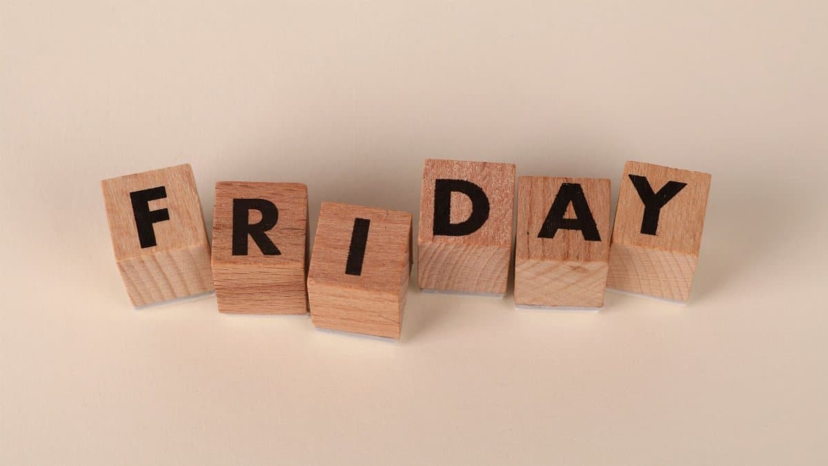 Wooden letter blocks spelling out 'Friday' on a neutral beige background.