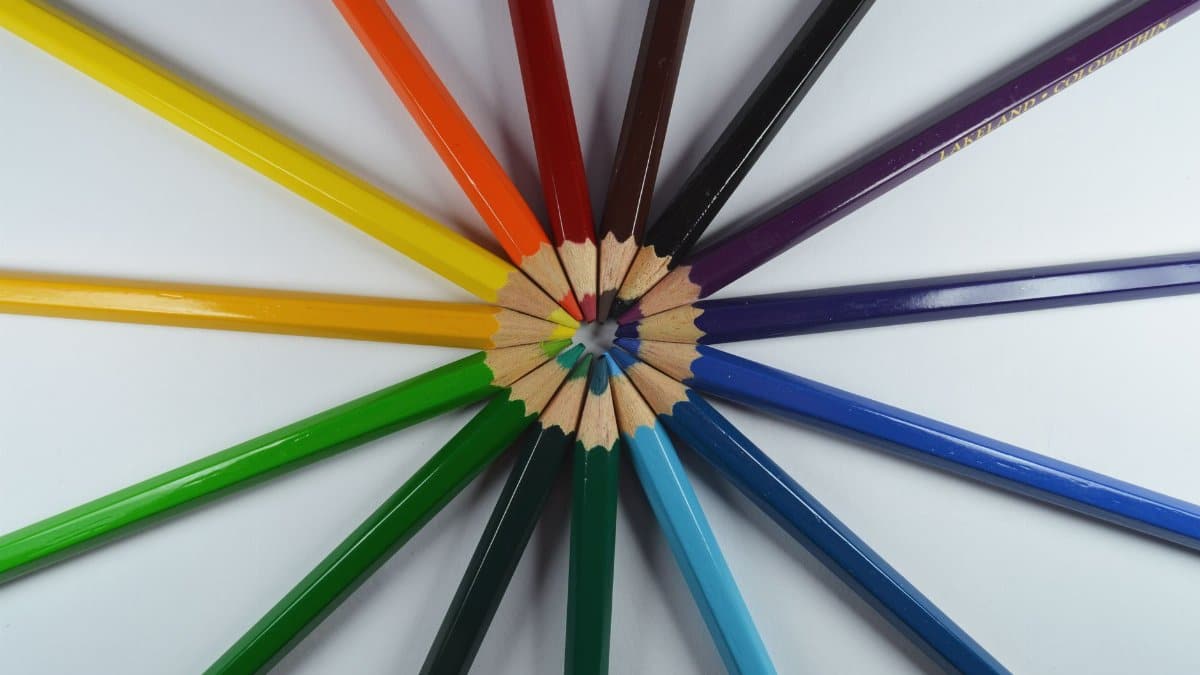 Circle of colorful pencils creatively displayed on a white background.