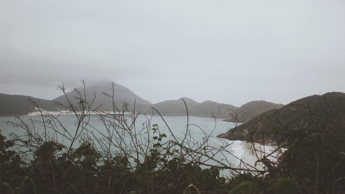 Breathtaking view of Arraial do Cabo's misty coast with hills and ocean.