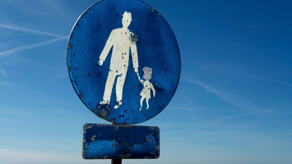 An old, weathered pedestrian road sign with clear sky background, indicating a worn path.