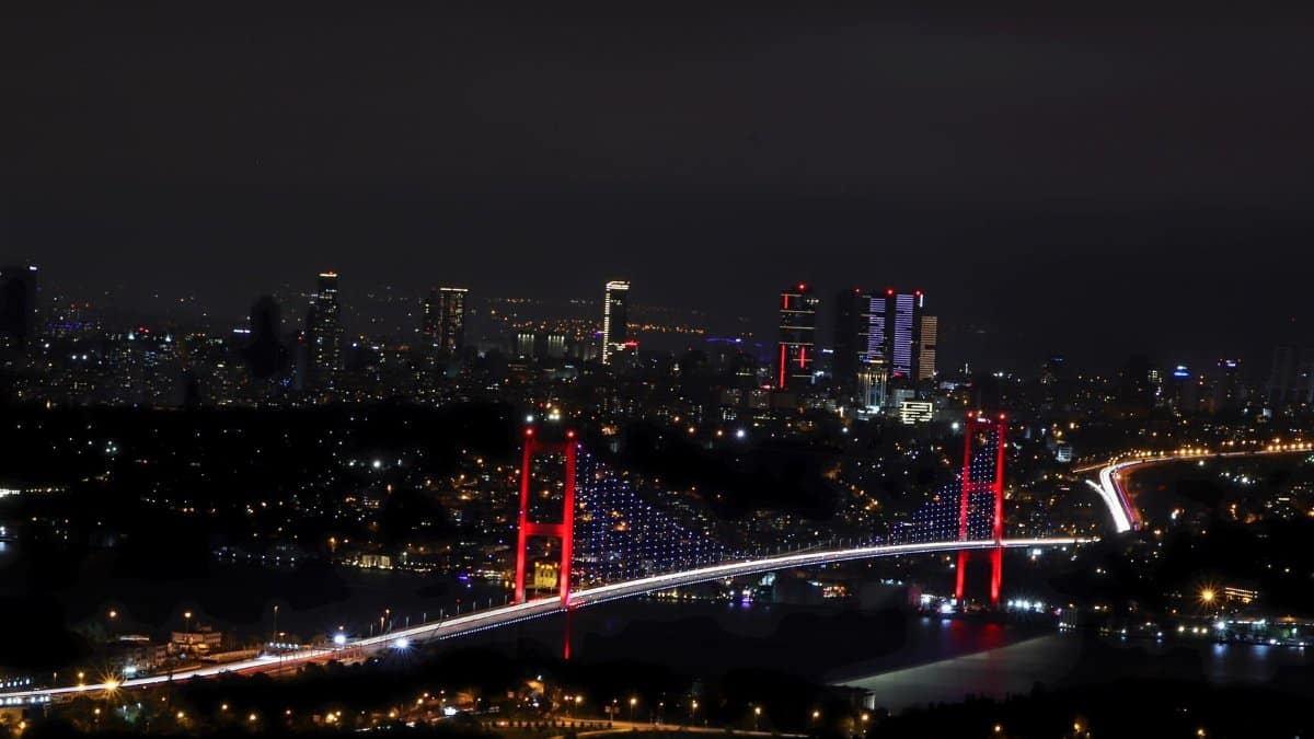 A stunning night view of the Bosphorus Bridge in Istanbul, brightly lit against the city skyline.