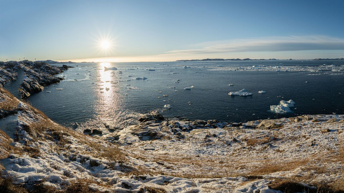 Beautiful snowy coastline and icy waters in Nuuk, Greenland under the bright winter sun.
