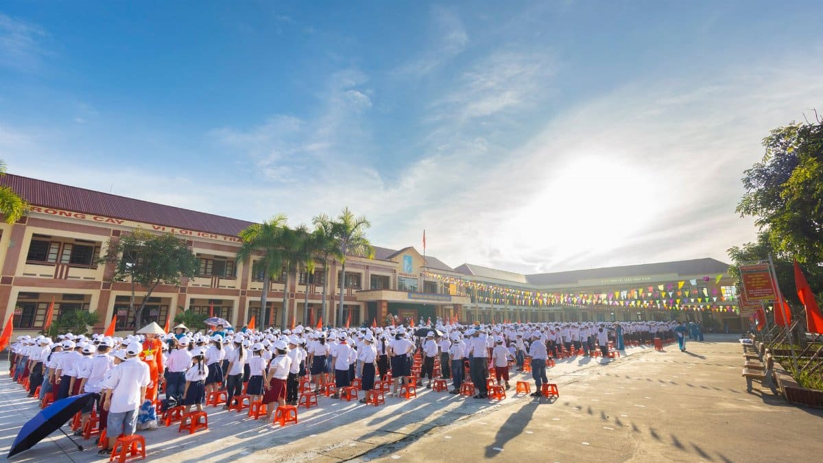A large group of students in uniform gathered outdoors for a school assembly.