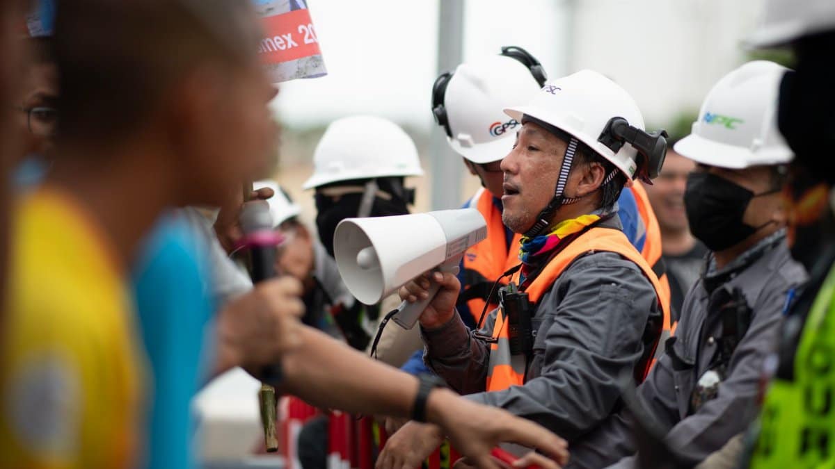 Construction workers in a heated protest with security present. Safety and communication emphasized.