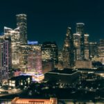 A breathtaking view of Houston's cityscape, illuminated at night with skyscrapers and bustling streets.