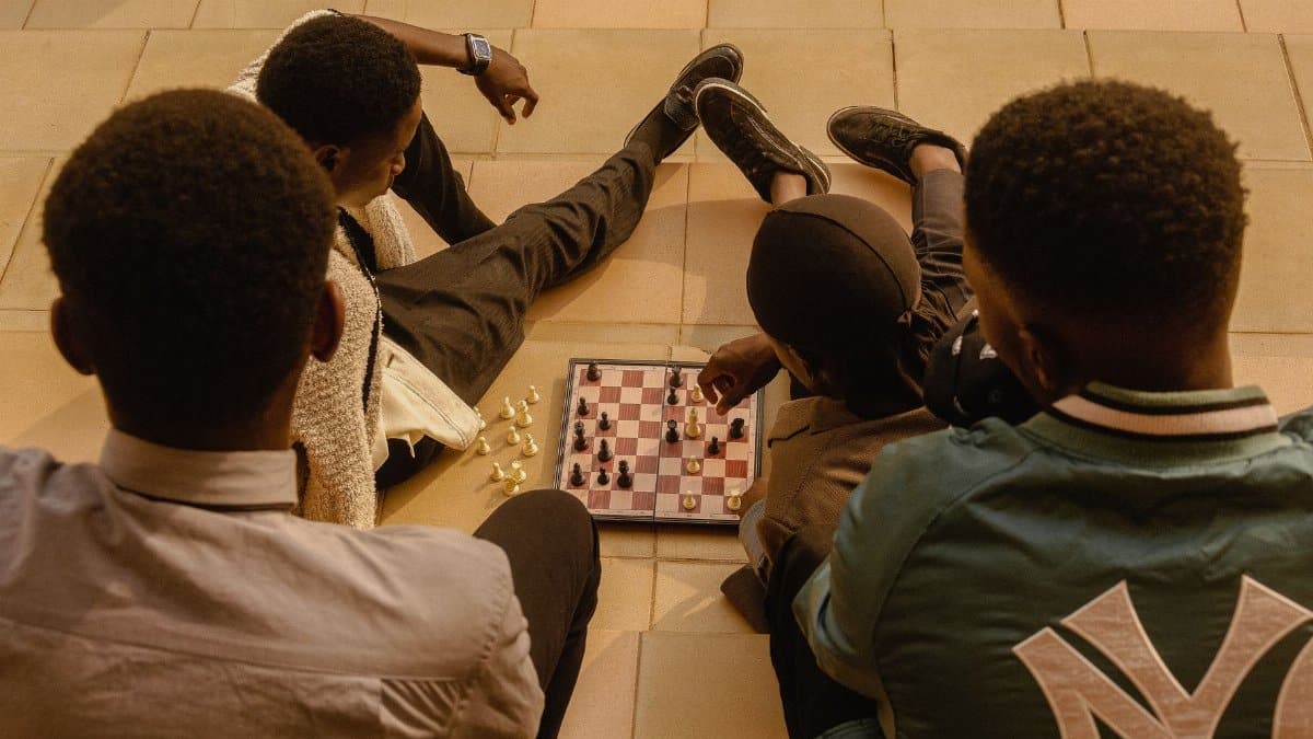 A group of youth engaging in a chess game outdoors in Ado Ekiti, Nigeria.