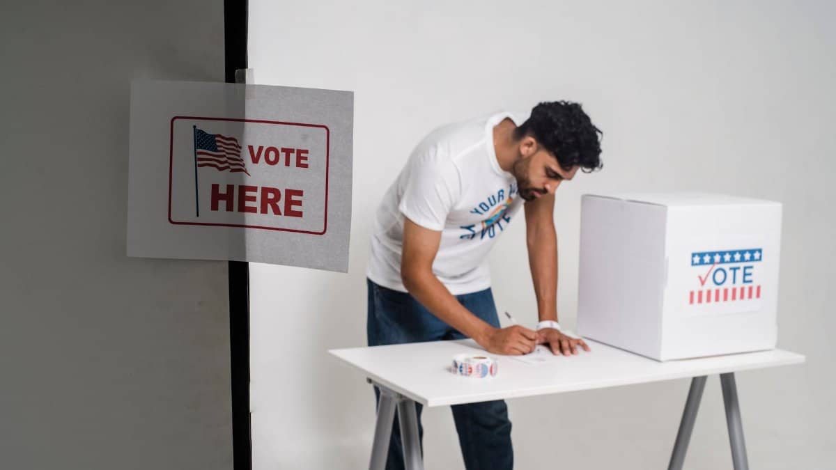 A man casting his vote in a ballot box, highlighting the democratic process in a studio setting.