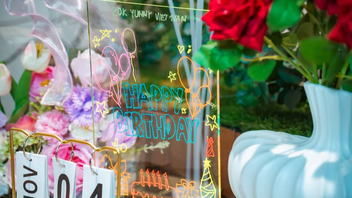Vibrant birthday greeting with floral decor and date indication.
