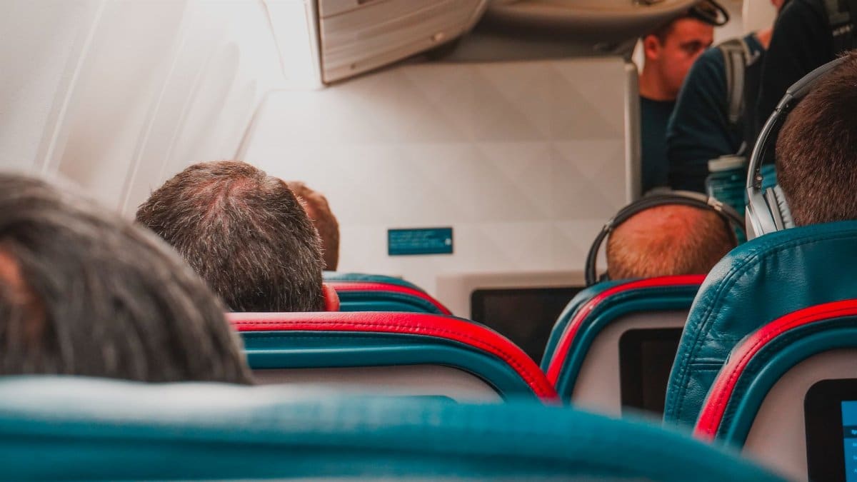 Interior view of an airplane cabin with passengers seated, focusing on seats and layout.