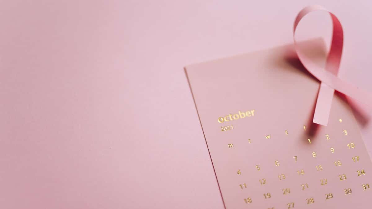 October breast cancer awareness with pink ribbon and calendar highlighting the fight against cancer.