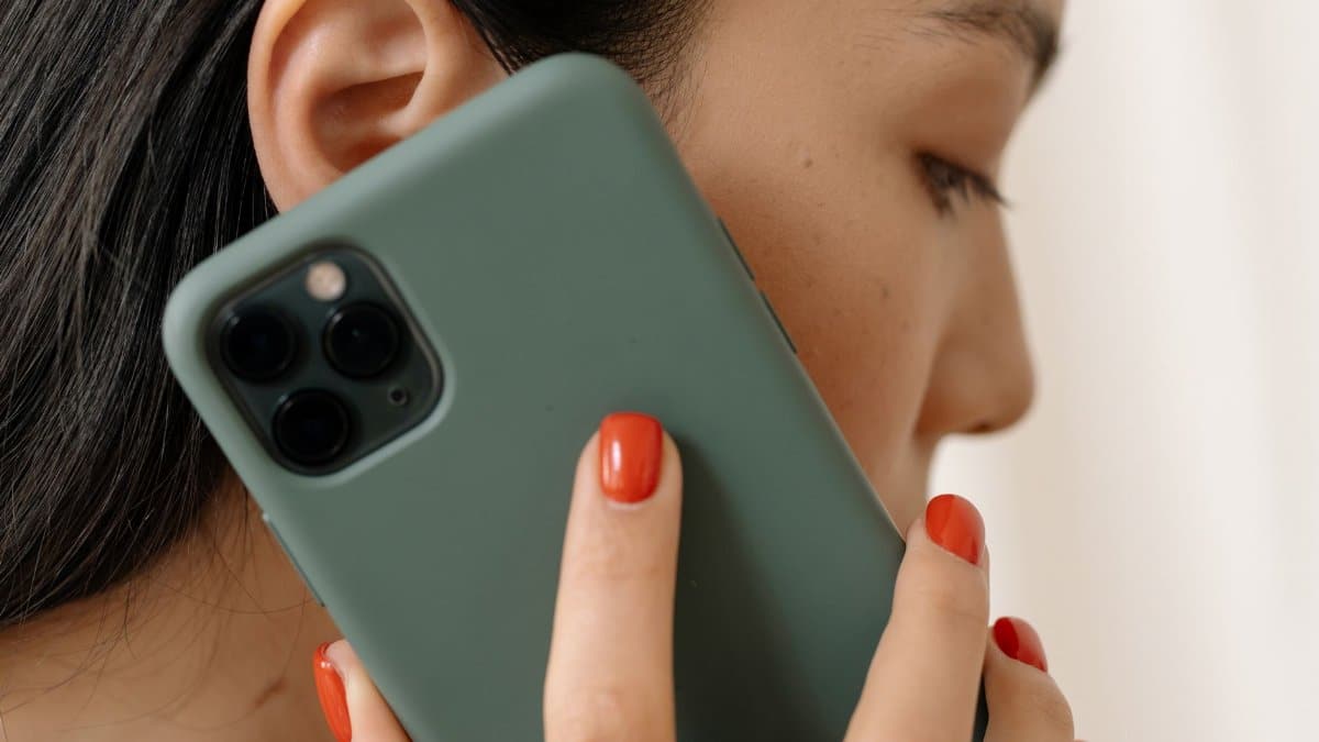 Close-up of an Asian woman holding a smartphone to her ear seems to be on a call.