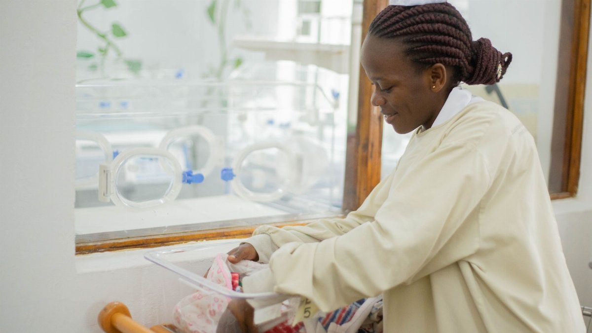 A nurse tending to a newborn in a hospital nursery, showing care and compassion.