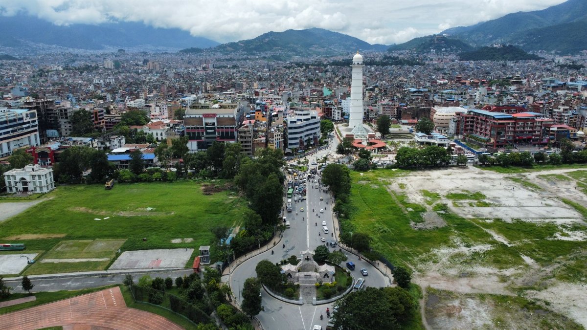 Stunning aerial view of Kathmandu city with a prominent white tower and lush greenery.