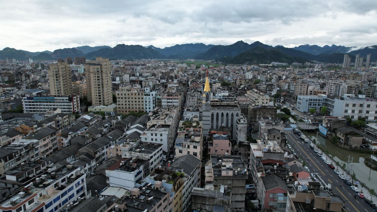Aerial view of Jiaojiang District, Taizhou City, showcasing urban landscape and distant mountains.