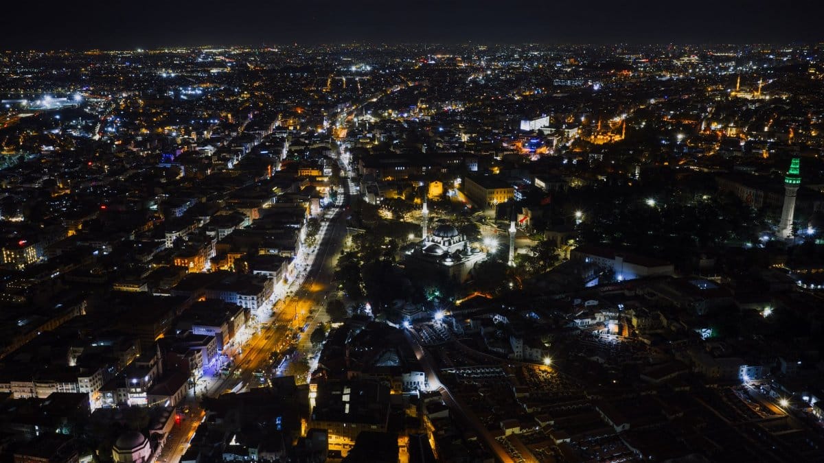 Explore the stunning night view of Istanbul, illuminated with city lights from an aerial perspective, capturing the vibrant essence of Türkiye's cultural heart.