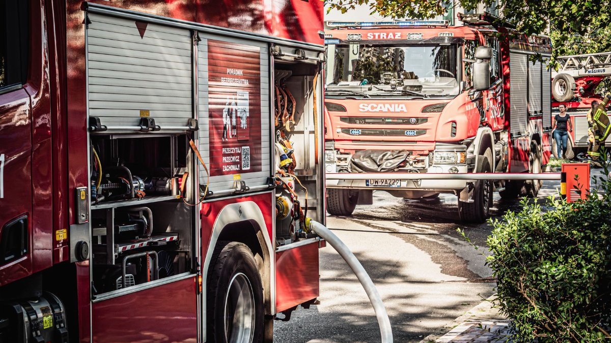 Fire trucks and firefighters at a scene in Wrocław, showcasing emergency response.