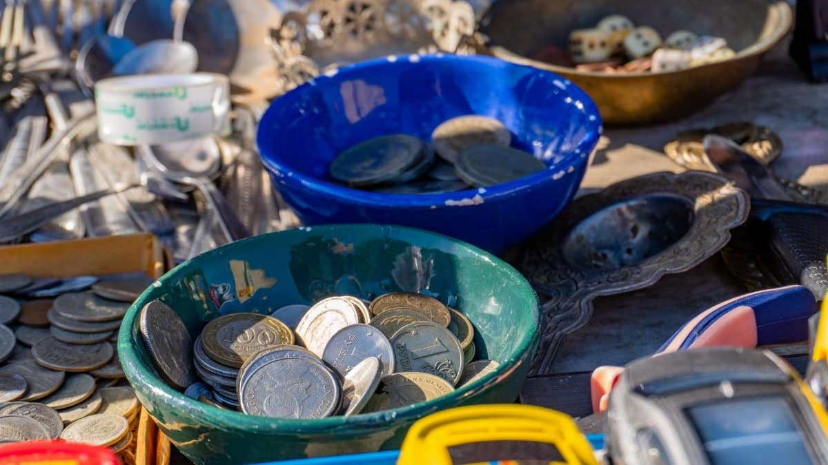 Vibrant display of coins and trinkets in a Baku bazaar, featuring colorful bowls and vintage items.