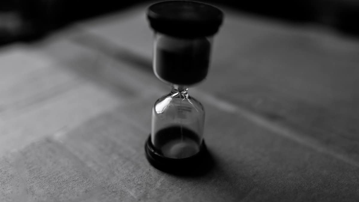 Artistic black and white close-up of an hourglass symbolizing time and patience.