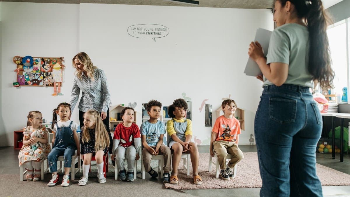 Diverse group of preschool children and teachers in an engaging classroom setting.