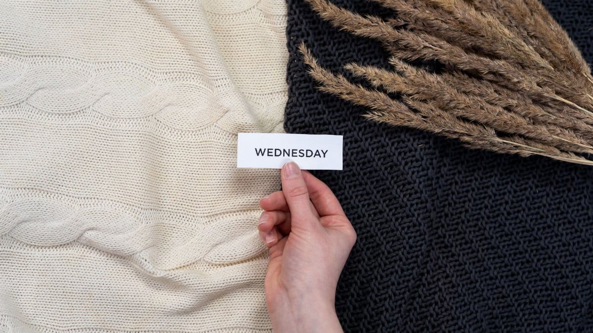 Elegant flat lay with a Wednesday card over woolen blankets and dried florals. Perfect for cozy, aesthetic content.