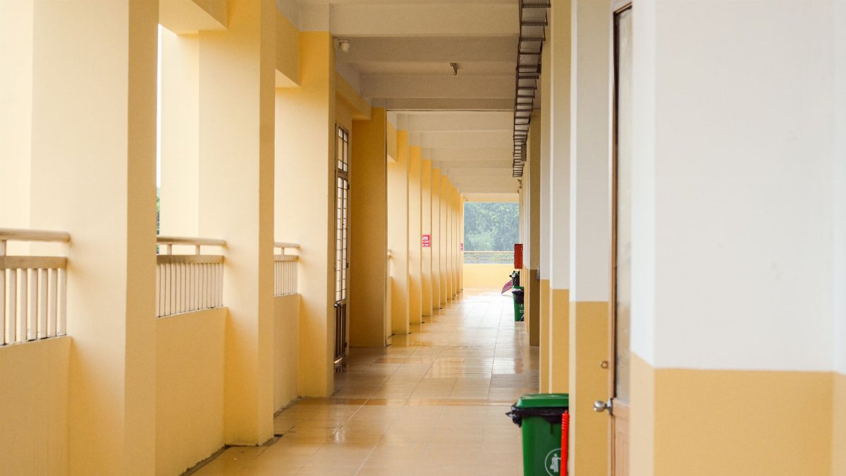 A spacious yellow corridor with trash bins, ideal for background or architectural themes.