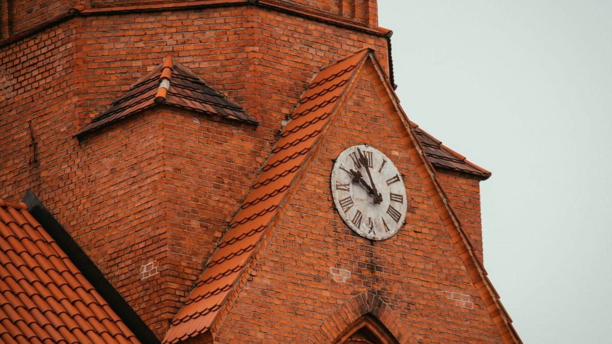 Close-up of a historic clock tower with red brick details in Druskininkai, Lithuania.