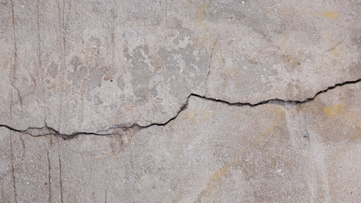 Detailed texture of a weathered concrete wall showing crack patterns.