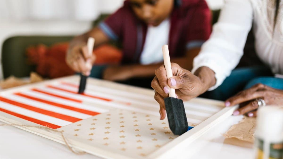 Mother and son bonding over an American flag craft project at home.