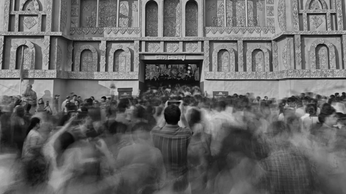 Black and white image of a crowd celebrating Durga Puja at a temple in Kolkata.