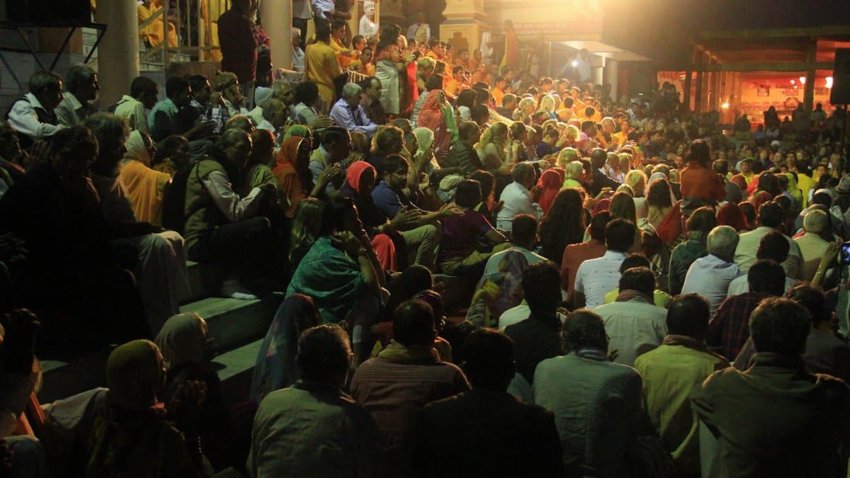 A vibrant crowd gathered at night for a cultural ceremony outdoors in India.