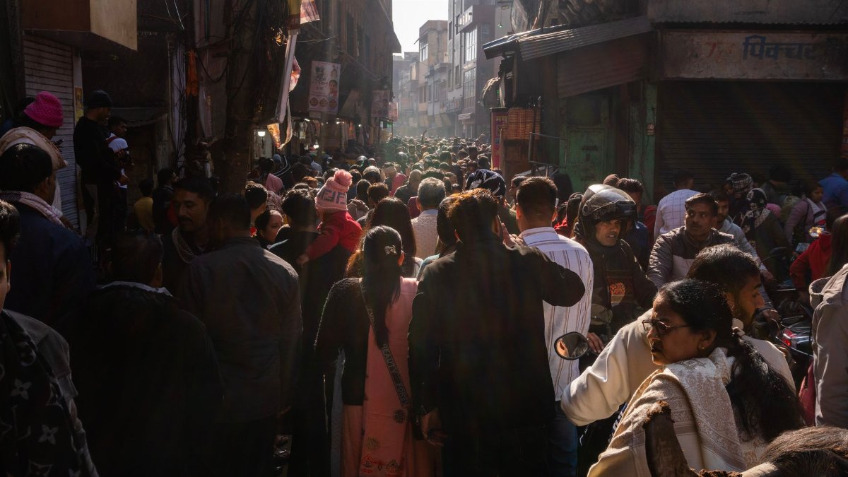 A bustling street market in India with a diverse crowd and vibrant atmosphere.