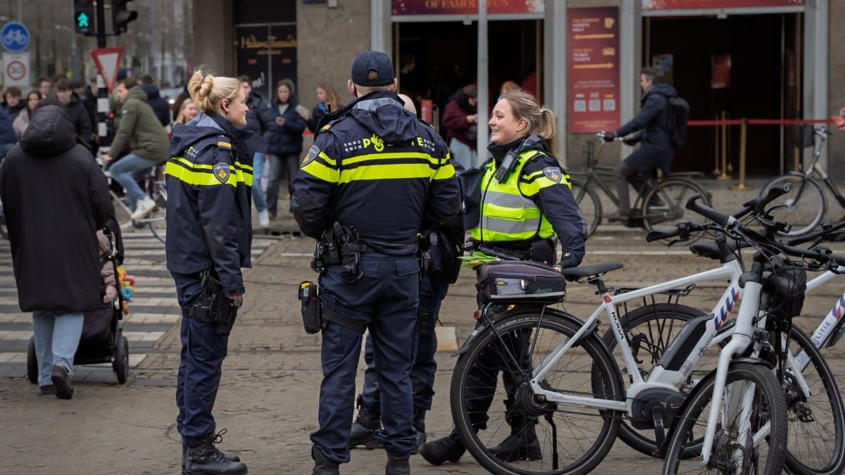 Police officers on duty in a busy urban street, interacting with bicyclists.