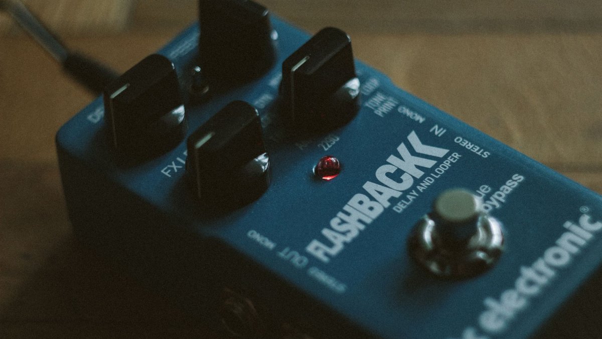 A detailed view of a blue Flashback delay and looper pedal with control knobs.
