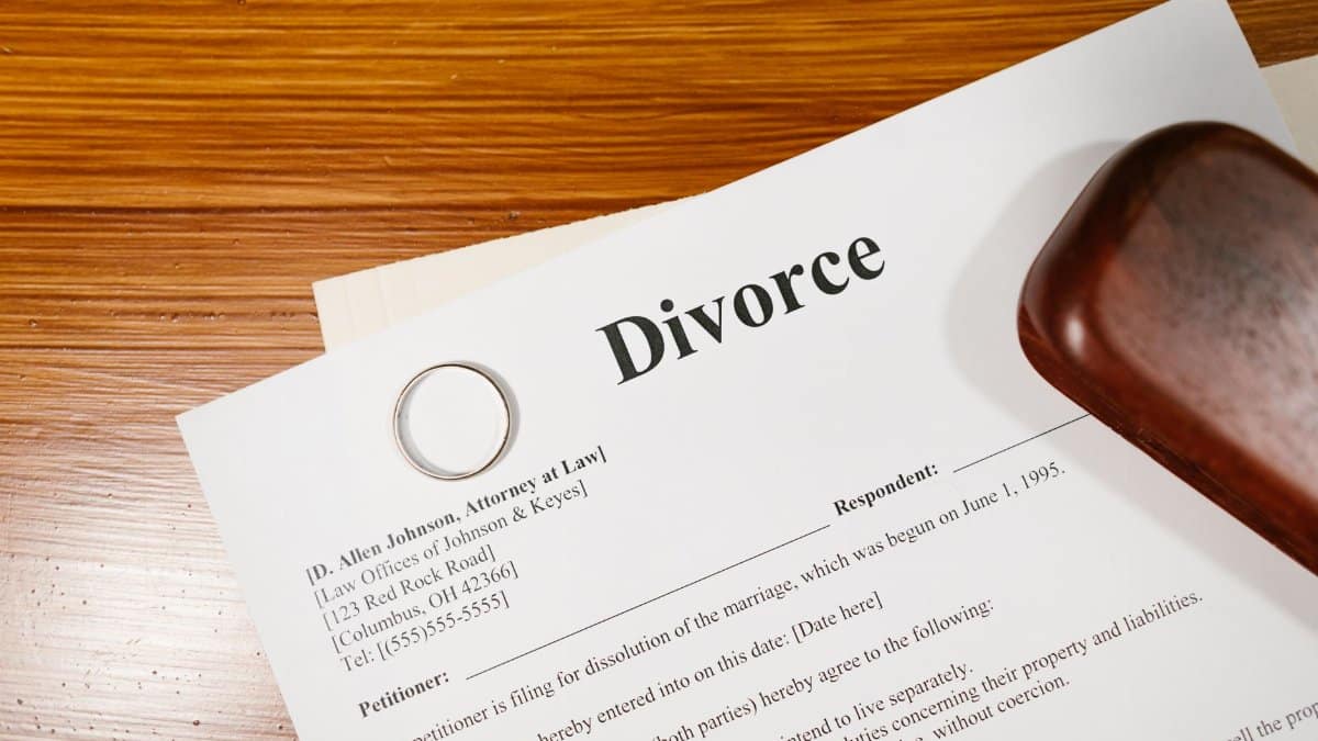 Close-up of a divorce document and wedding ring on a lawyer's desk.