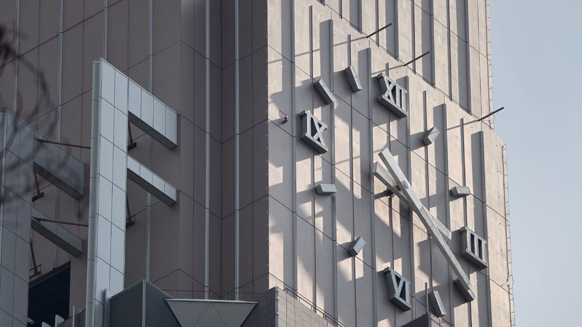 Analog clock on a modern high-rise building in Tokyo, Japan during daylight.