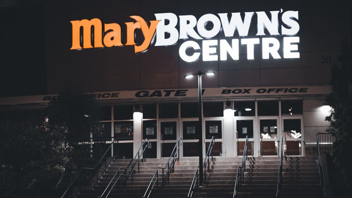 Night view of Mary Brown's Centre entrance with neon signage and steps.